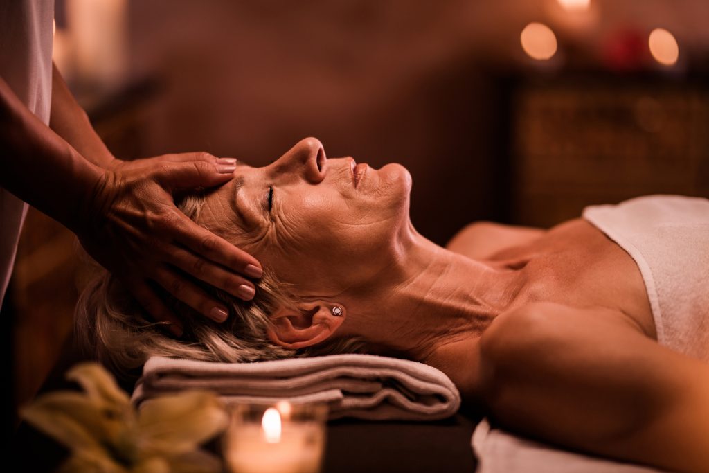woman having head massage by unrecognizable therapist at the spa - Sharon Carr Travel, Dallas 