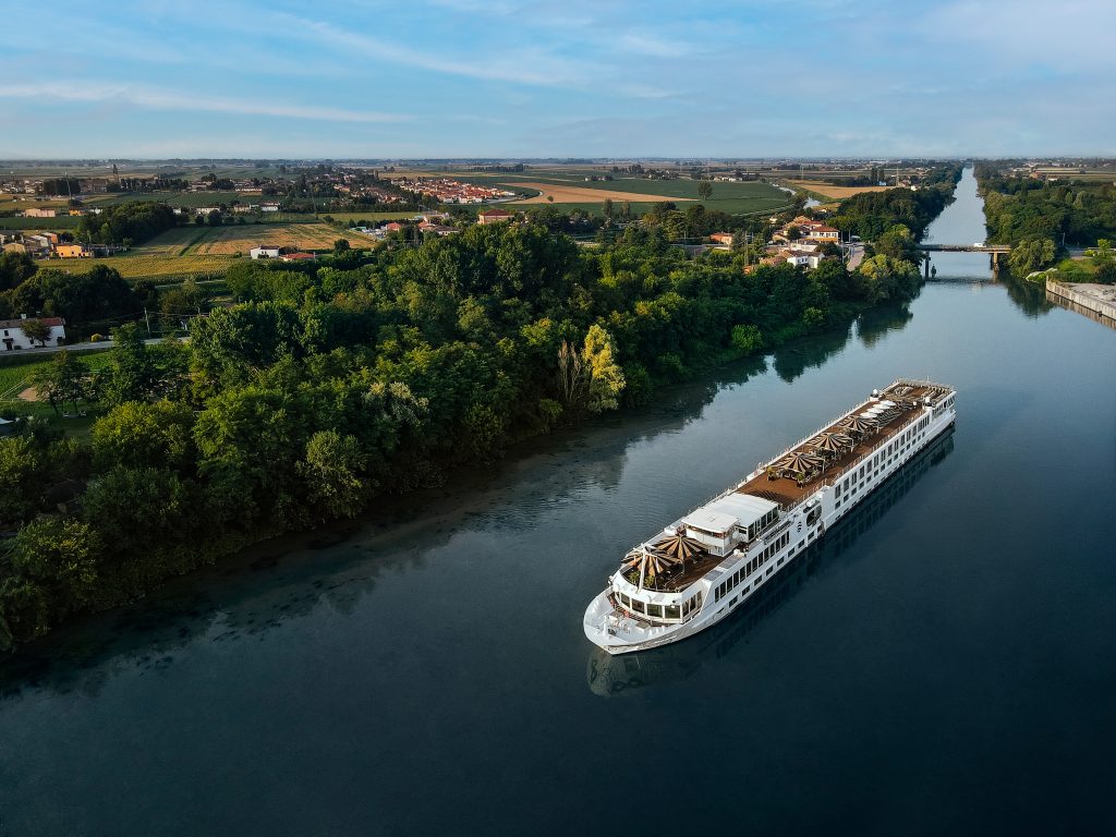 Uniworld river cruise ship sailing down a river in Europe - Sharon Carr Travel 
