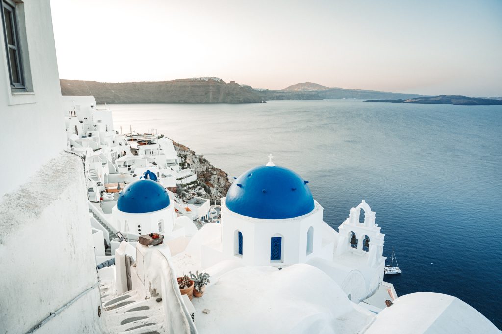 Santorini blue domed churches at sunrise - Sharon Carr Travel