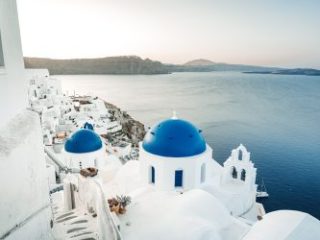 Santorini blue domed churches at sunrise - Sharon Carr Travel